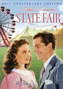 DVD Cover for the movie State Fair. A young woman and man look at each other with a ferris wheel in the background.